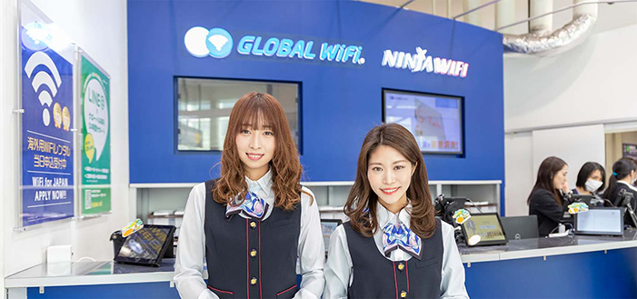 グローバルWiFiのカウンター　制服姿で笑顔の女性スタッフ２人