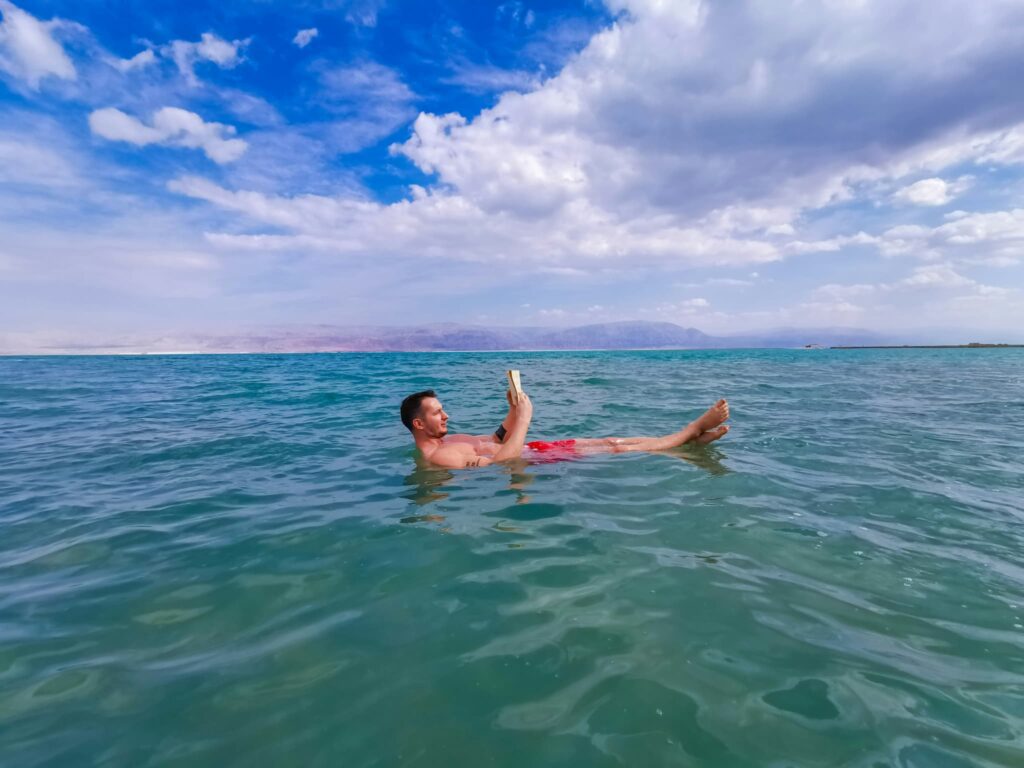 海で浮かびながら読書する鍛えられた体の短髪の男性