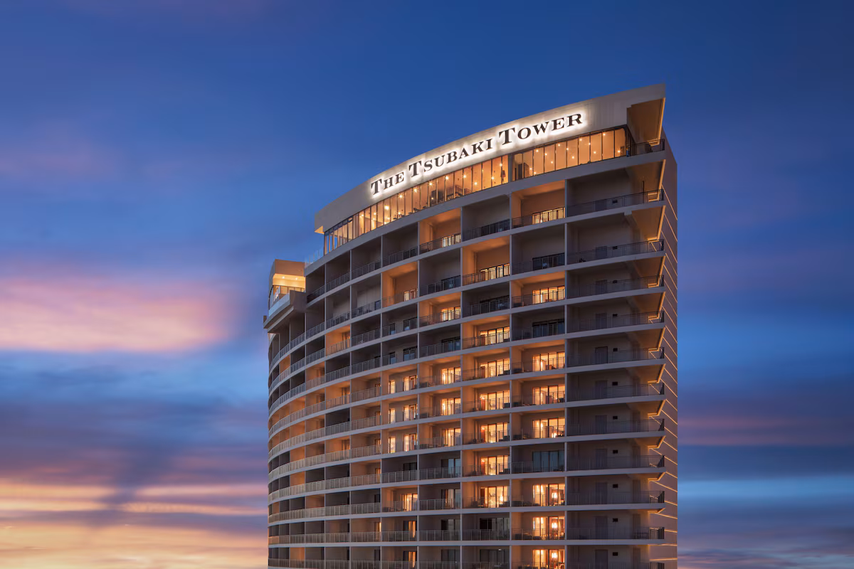 日没後幻想的な空とザ ツバキタワー 灯りがついている最上階のラウンジや、客室。外観のTHE TSUBAKI TOWERが光っている。