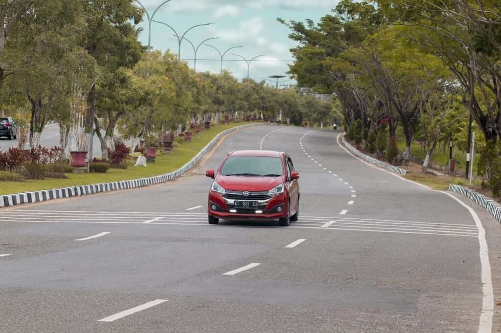 ３車線の緩やかなカーブを走る赤い車